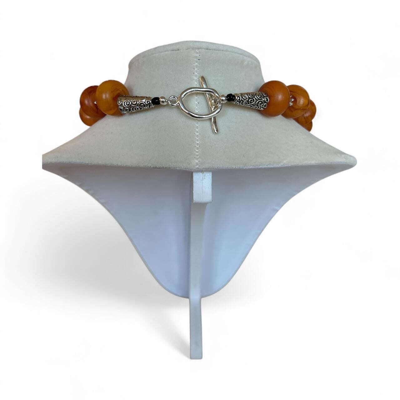 Exclusive Peggy Goodman necklace featuring genuine amber beads and bold black agate stone centerpiece, handmade jewelry at Aqualta 2