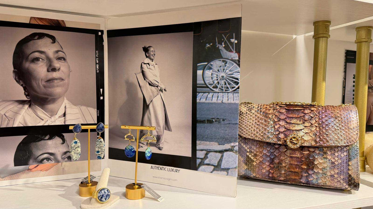 Aqualta boutique accessories display featuring designer earrings and a textured luxury handbag.