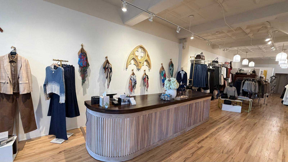 Aqualta fashion store interior with curated women’s apparel, scarves, handbags and accessories.