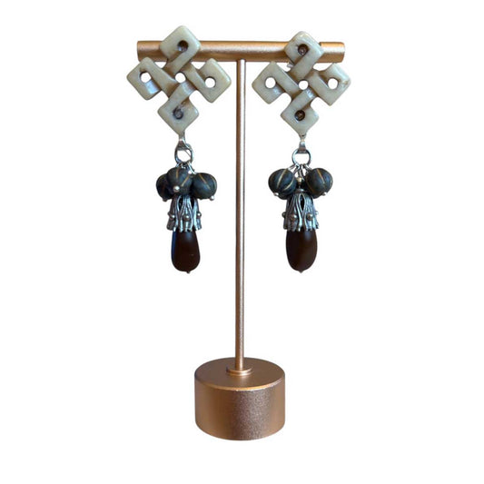 Peggy Goodman statement earrings with carved bone geometric tops and dark bead drops, available at Aqualta.