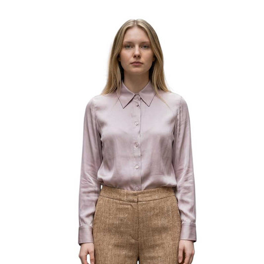 Woman wearing a light pink blouse and beige pants sand sold at Aqualta