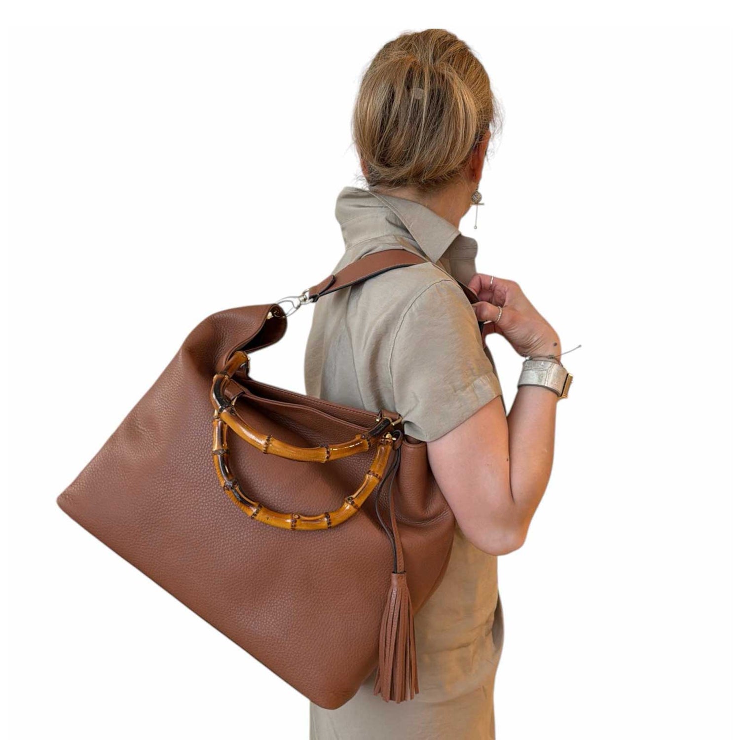 Woman carrying a Large leather tote bamboo handles Cognac Biagini sold at Aqualta