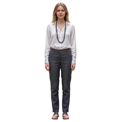 Model wearing a Peggy Goodman long multi-strand beaded necklace over a white blouse, styled with gray trousers, at Aqualta.