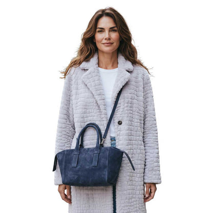 A woman wearing a Small Suede satchel Blue Biagini sold at Aqualta