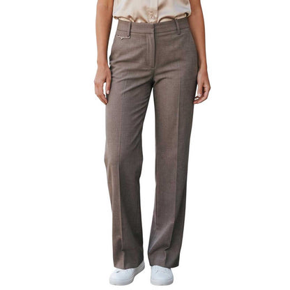 Woman wearing straight leg taupe trousers by Sand, sold at Aqualta, styled with a short-sleeve satin blouse and white sneakers.