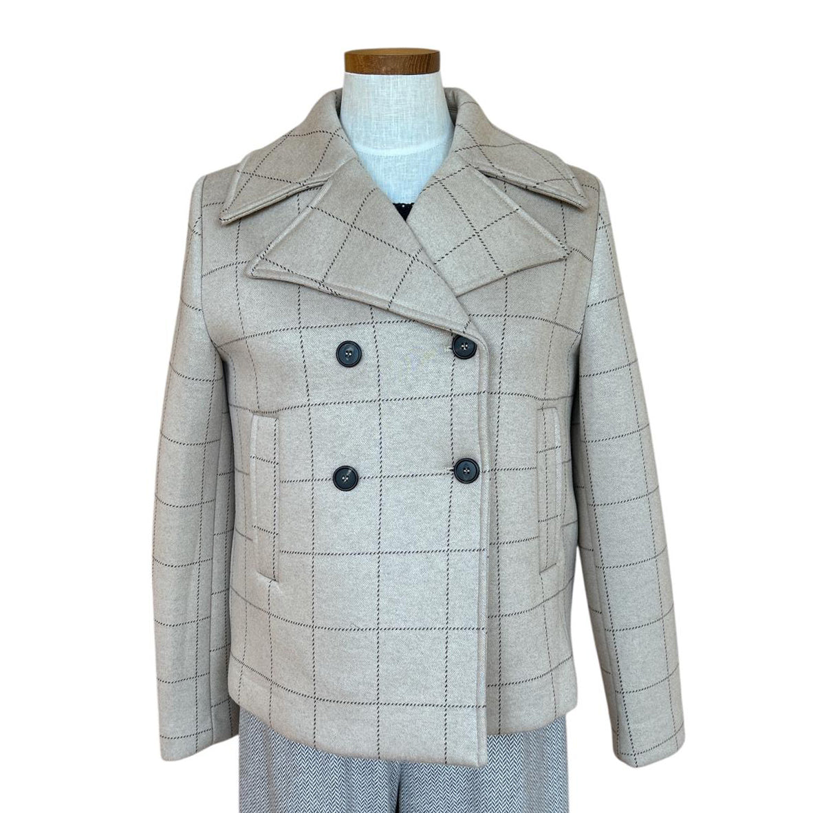 Plaid patterned coat on a mannequin against a white background Sold at Aqualta