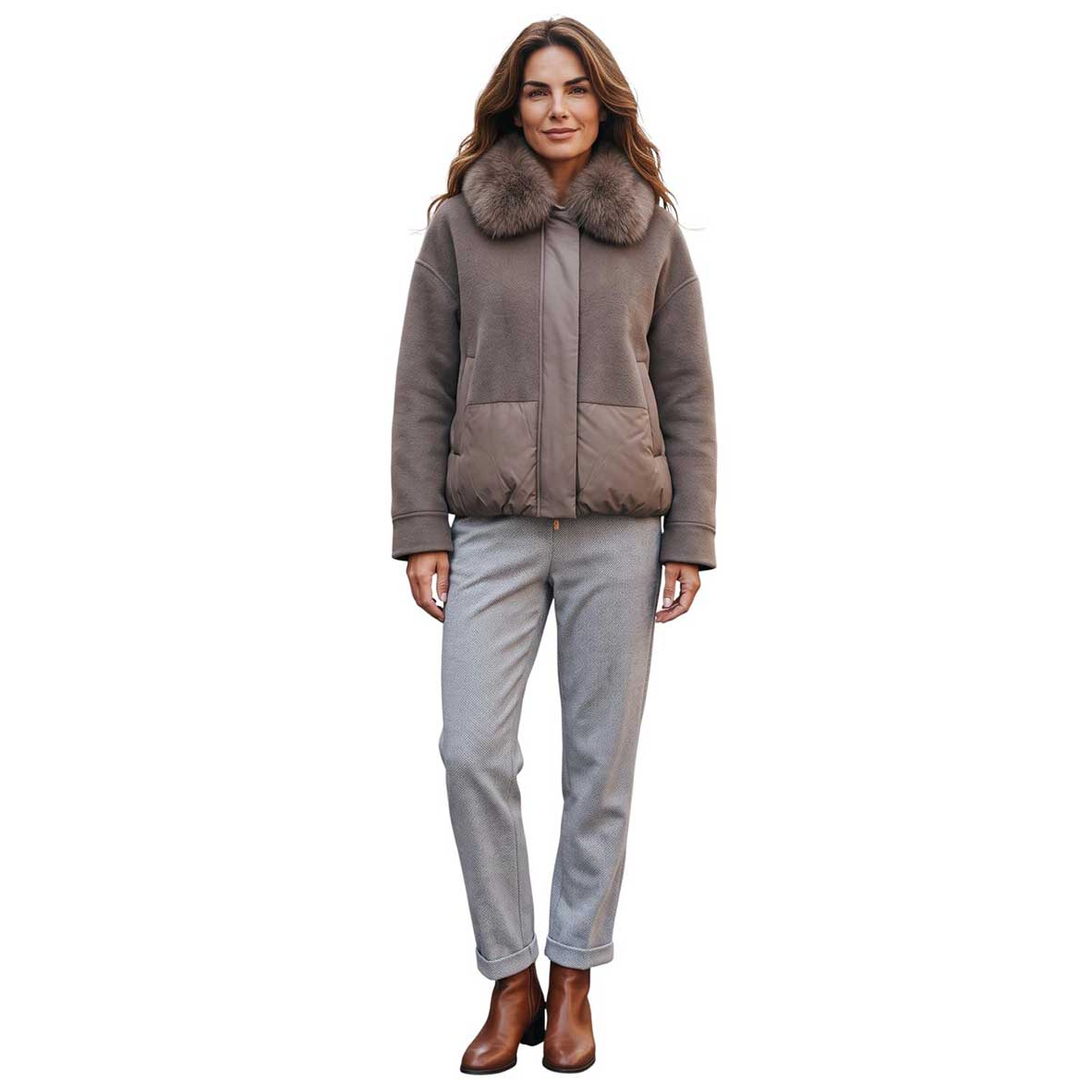 A woman modeling a taupe shearling-style jacket with a large brown faux-fur collar, paired with light gray pants and brown boots, against a plain white background.