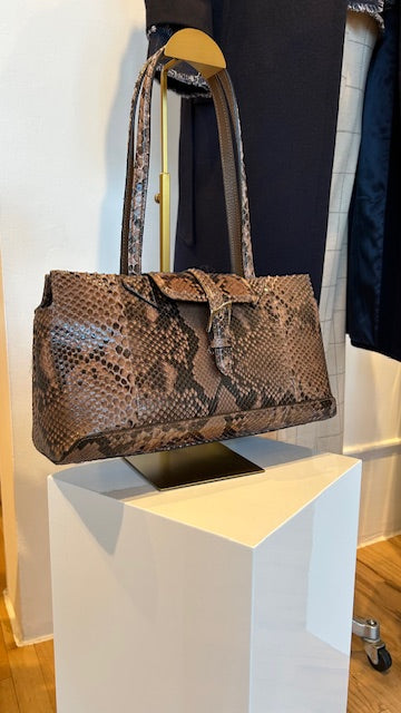 Luxury snakeskin handbag displayed on a pedestal inside the AqualtaWear boutique.