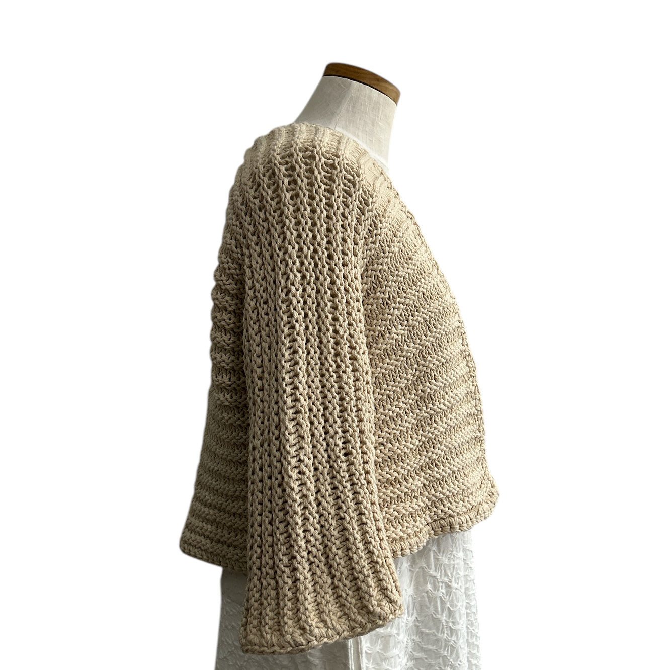 Lightweight beige open-knit shrug from Chiara Toffanin, available at Aqualta