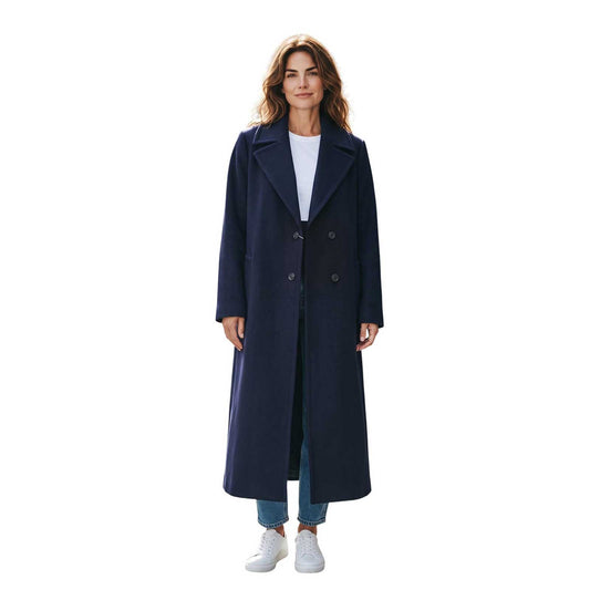 Woman wearing a long navy cashmere blend coat by Sand, sold at Aqualta, with a white top, blue jeans, and white sneakers.
